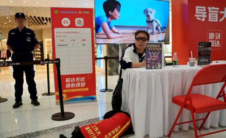 img：Prudence Interactive's visually impaired employee Baima and his guide dog Yani at the company's recruitment booth.
