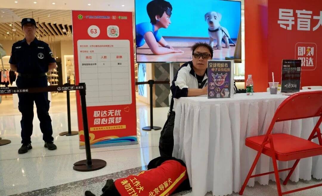 img：Prudence Interactive's visually impaired employee Baima and his guide dog Yani at the company's recruitment booth.