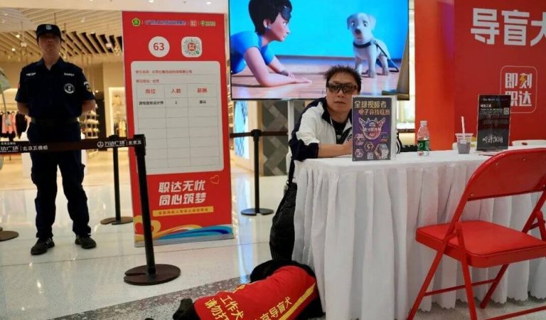 img：Prudence Interactive's visually impaired employee Baima and his guide dog Yani at the company's recruitment booth.